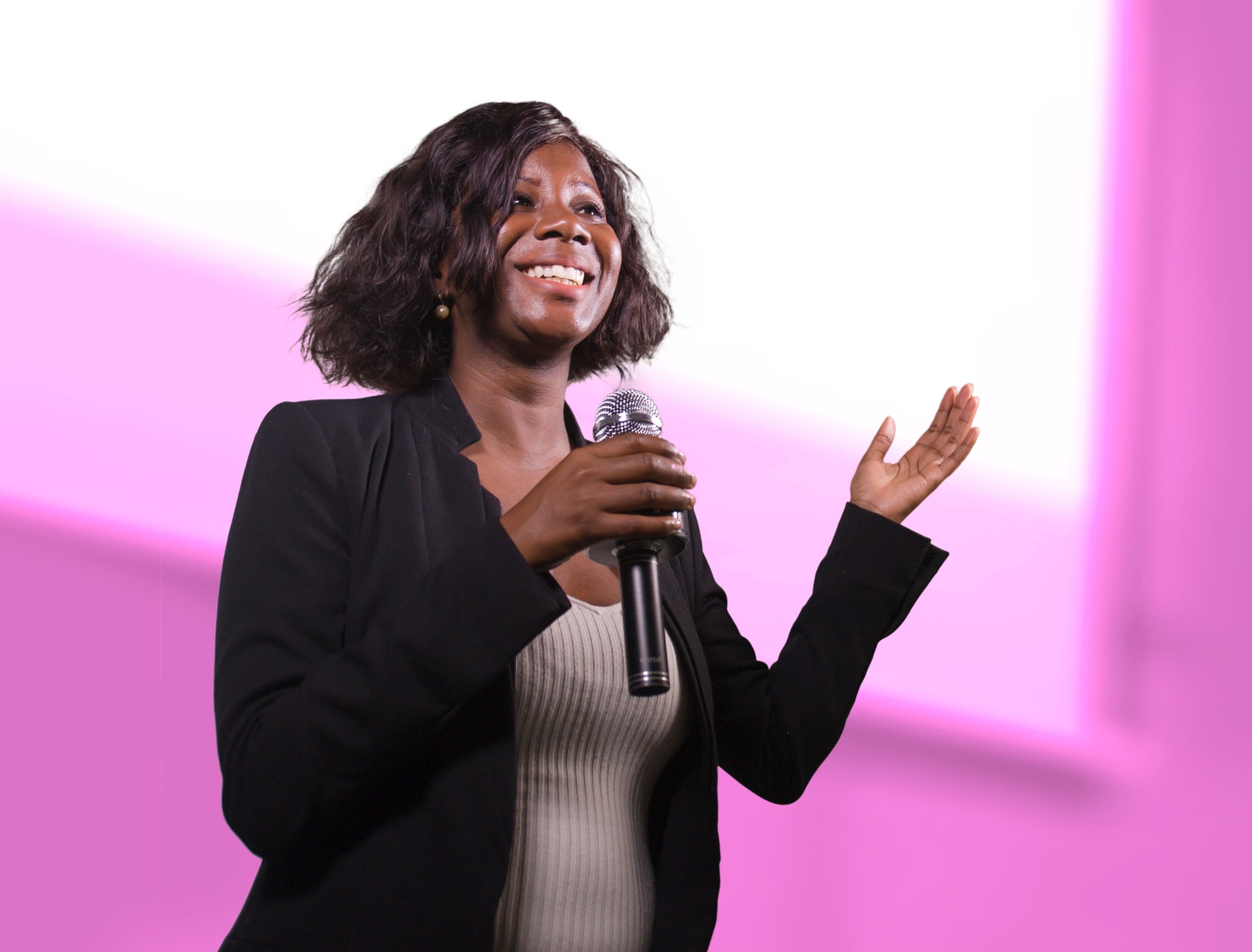 young attractive and confident black afro American business woman with microphone speaking in auditorium at corporate event or seminar giving motivation and success coaching conference