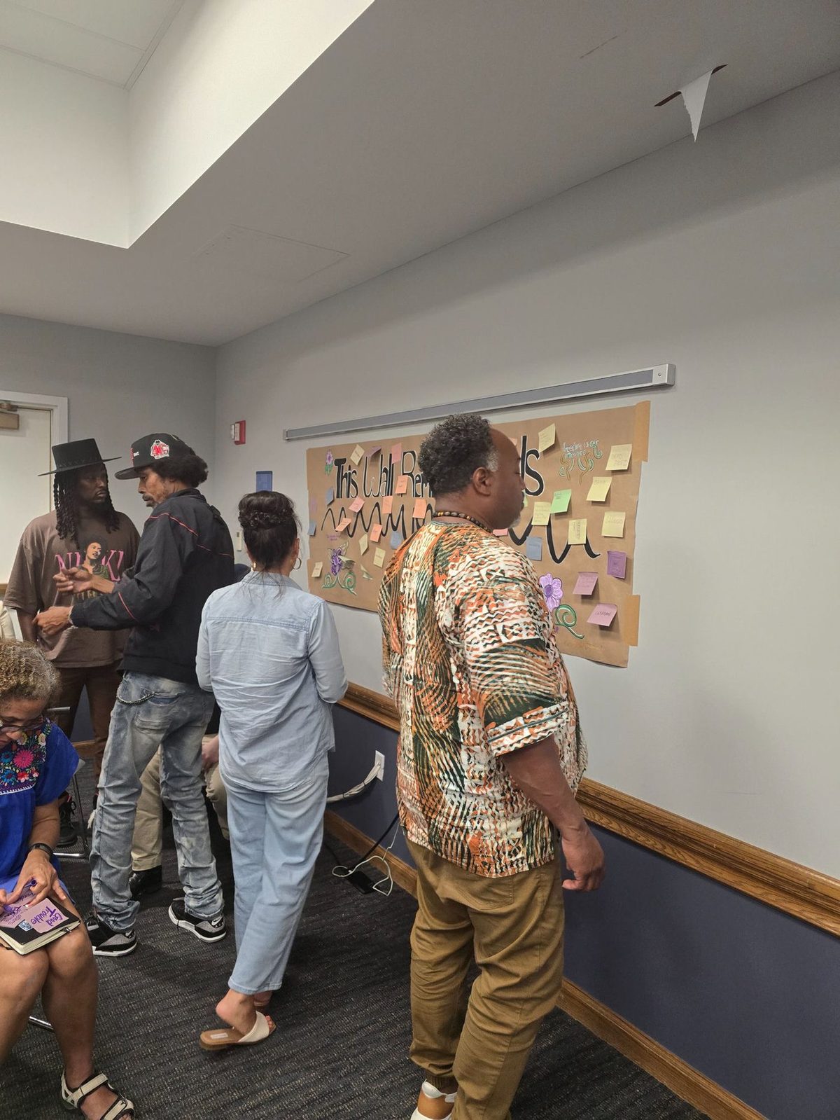 Participants adding memories to a wall titled This Wall Remembers during a Parties as Portals session